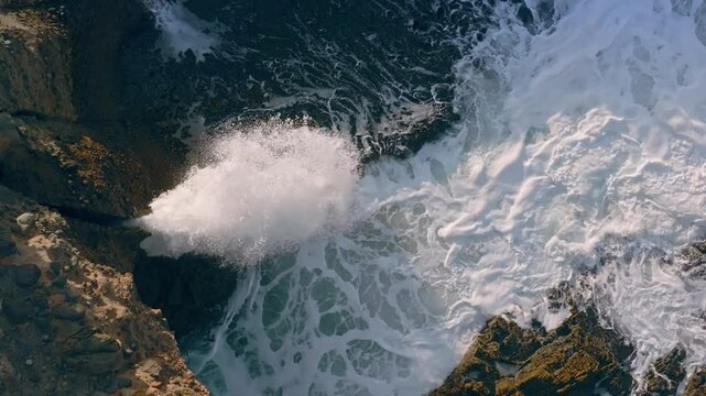 Waves squirting through chutes in rough seas in Piha, Auckland, New Zealand.