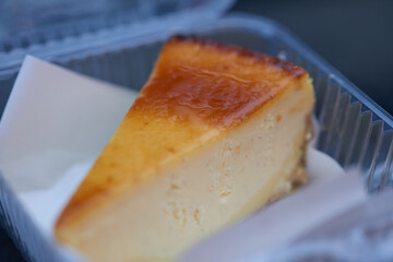 Close-up of cheese pie in plastic container, showcasing creamy filling and glossy flaky crust.