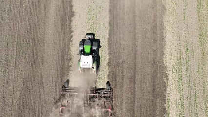 bird`s eye view of tractor cultivating field