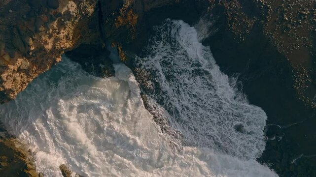 Waves squirting through chutes in rough seas in Piha, Auckland, New Zealand.
