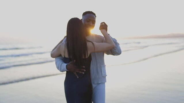 A man and a woman are standing on the beach, holding hands and smiling - Powered by Adobe