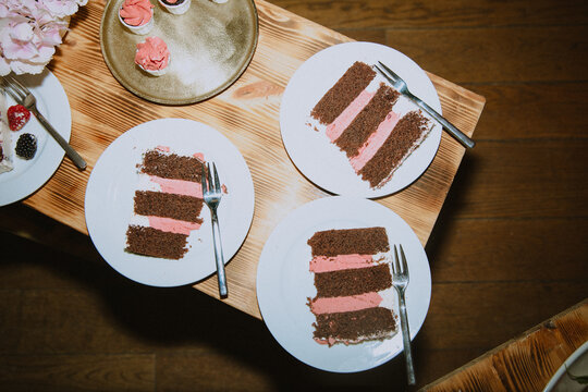 slices of wedding cake with chocolate and berry on wooden table