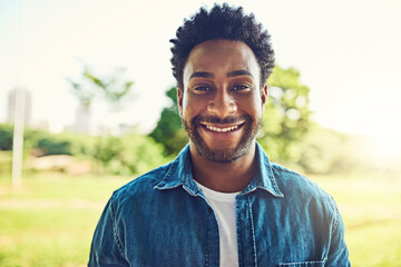 Happy, face and black man in spring, field and park with carefree, sunshine and nature in countryside. Person, smile and relax in portrait with calm, hobby and wellness for summer walk and relaxing