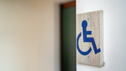 Toiled reserved sign for disabled person that made from wooden plate, installed at the wall in...