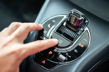Action of driver finger is pressing on the start button to starting the car engine. Close-up and...