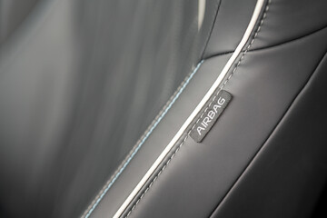 "Airbag" tag on the car passenger or driver black leather seat. Transportation sign on equipment object, close-up.
