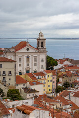 Fototapeta premium Lisbons old town presents a charming scene with classic buildings and a riverside church. The citys European heritage comes alive in its historic architecture and picturesque location