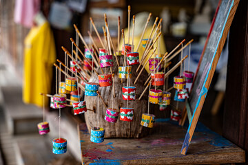 Thai retro toy called "Jak ka jan ".  Sound like a cicada bug when swing it. It make from bamboo,clay, small rope and color paper. © Silapavet