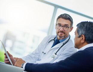 Fototapeta premium Doctor, men and tablet for consultation or visit to clinic, talking and treatment for healthcare. Mature specialist, speaking and medical records for senior patient diagnosis, cardiology and help