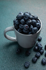 Blueberries in a cup on a dark background. Top view.