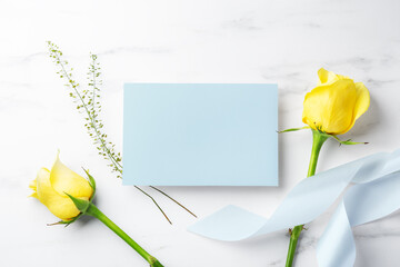 Blue card with yellow roses and ribbon on white table background