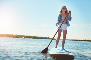 Portrait, paddleboard and girl with vacation travel and stress relief with hobby, getaway trip and...