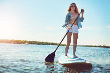 Portrait, paddle and woman with surfboard, travel and stress relief with hobby, getaway trip and break. Face, person and girl with water, summer holiday or vacation with adventure, fitness or journey