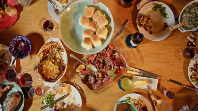 4K Ultra HD Video of Top Down Shot of People Gathered Around Dining Table for Friendsgiving Party Passing Plates of Food
