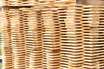 This image showcases a pile of neatly stacked wooden planks, varying in shades and textures, creating a rustic and organized appearance perfect for construction or carpentry themes.