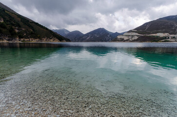 mountain lake with clear water and high mountains and clouds