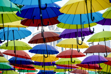 Obraz premium many colorful umbrellas fly and hover on the city street
