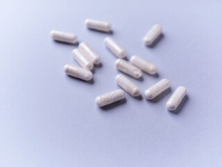 Tyrosine capsules (one of the 20 standard amino acids). A dietary supplement used to improve attention and focus on paper background. Soft focus. Close up.
