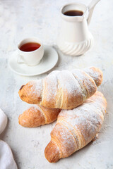 Croissants on the table. Sprinkle the croissants with powdered sugar. The concept of breakfast. Traditional French pastries.