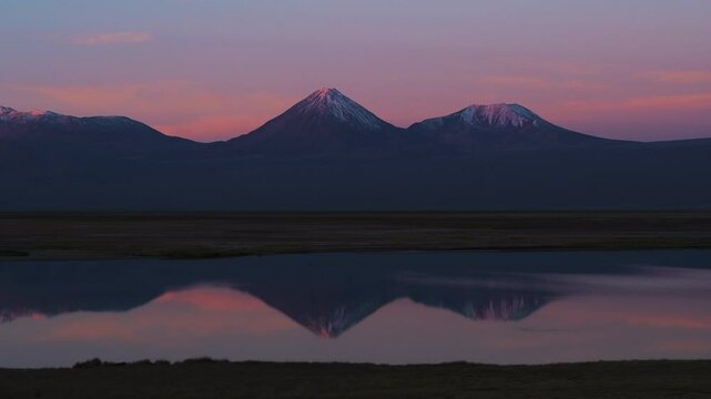 Aerial: Drone Panning Beautiful Shot Of Tranquil Licancabur Mountains By Tranquil Lake In Desert During Sunset - Atacama Desert, Chile