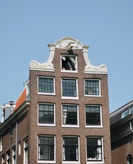 Fototapeta premium building in amsterdam with someone showing theitr feet in the window resting