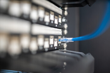 close up of network cables connected to server racks in data center room.