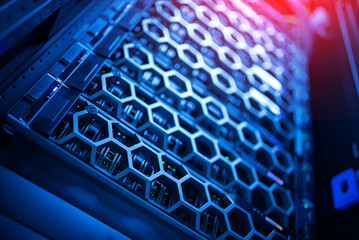 close up of network cables connected to server racks in data center room.