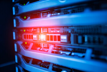 close up of network cables connected to server racks in data center room.