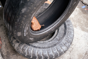 Car mechanic repairs punctured tire hit by nail on rim in service workshop. Close-up of a mechanic...