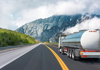 Fuel truck on a picturesque road. A silver tank truck transports fuel.