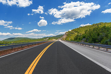 Country road with rocky mountains in the background.