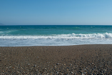 Pebble beaches. Beaches in Muğla. View from the beach to the sea. Magnificent beach, sea and blue cloudy sky.
