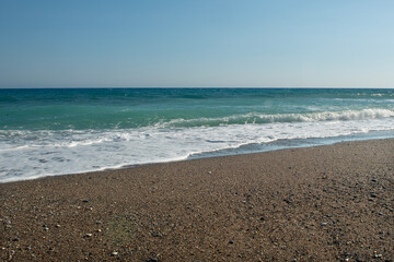 Pebble beaches. Beaches in Muğla. View from the beach to the sea. Magnificent beach, sea and blue cloudy sky.