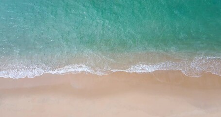 Aerial view drone shot Top-view of beach and sea, Seawater wave on sandy beach. Beach on the tropical island. (4K DCI 4096x2160p 10bit 4:2:2)