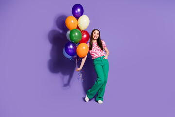 Full length photo of lovely young lady hold air balloons dressed stylish pink garment isolated on violet color background