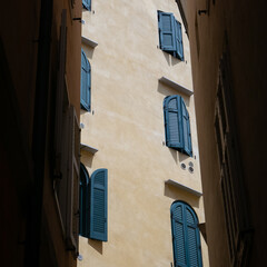 glimpse of a facade of a house with windows and shutters