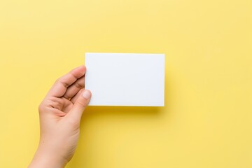 Fototapeta premium White blank empty postcard mockup in hand on Light Yellow background