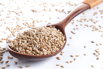 Rolled oats on wooden spoon isolated on white background, healthy breakfast cereal oat flakes 