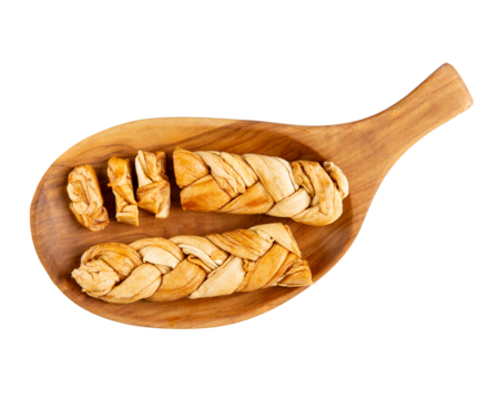 Braided dried melon. Dried melon in form of pigtail on wooden plate isolated on white background. Natural sweet dessert. Top view.