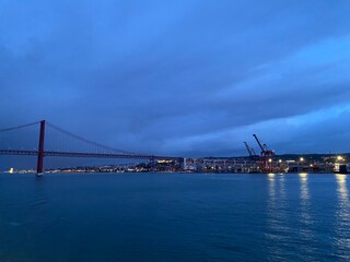 Fototapeta premium Panoramic view over the Ponte 25 de Abril and cranes in Lisbon harbour