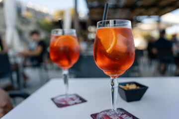 Two refreshing spritz cocktails standing on a table in a bar. Two refreshing spritz cocktails are...