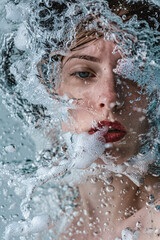 Portrait of young beautiful woman with wet hair and splashes of water