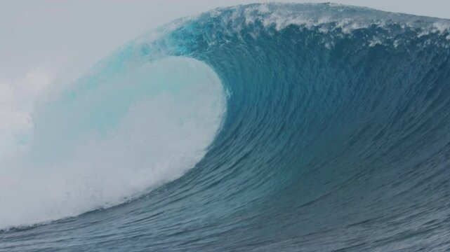 Thick heavy breaking wave curls with whitewash spilling out front of barrel