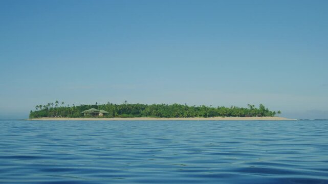 Short island in the South Pacific with home, huts, sandy shores, and tropical jungle