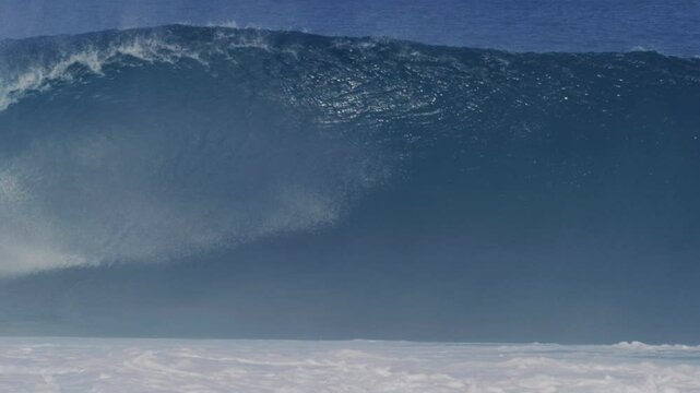 Huge wave spits spray out from barrely as it rises into empty hollow tube and mist floats off top
