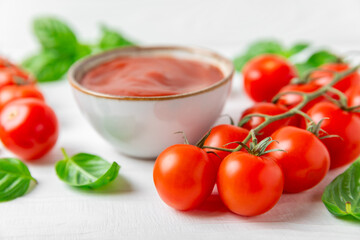 Fresh cherry tomatoes and fresh green basil on a textured background. Tomato sauce. Vegan. Ingredients for salad. Organic food. Place for text. Copy space.