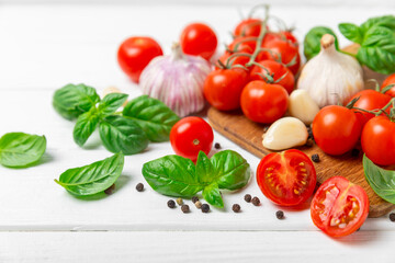 Fresh cherry tomatoes and fresh green basil on a textured background. Tomato sauce. Vegan. Ingredients for salad. Organic food. Place for text. Copy space.
