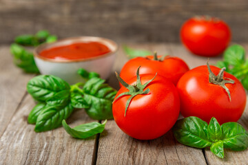 Fresh cherry tomatoes and fresh green basil on a textured background. Tomato sauce. Vegan. Ingredients for salad. Organic food. Place for text. Copy space.