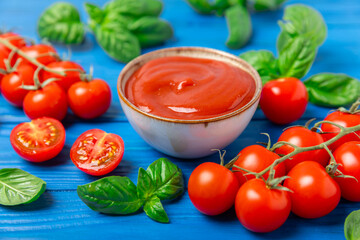 Fresh cherry tomatoes and fresh green basil on a textured background. Tomato sauce. Vegan. Ingredients for salad. Organic food. Place for text. Copy space.