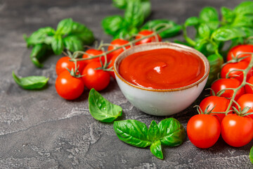Fresh cherry tomatoes and fresh green basil on a textured background. Tomato sauce. Vegan. Ingredients for salad. Organic food. Place for text. Copy space.